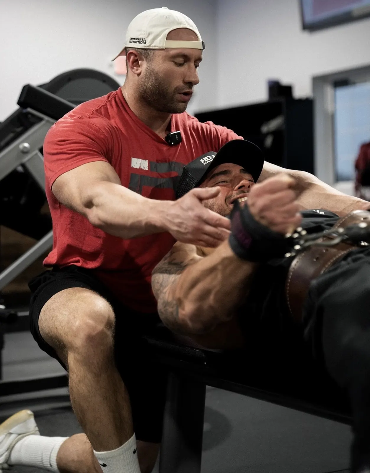 David DeMesquita coaching a client on a hack squat